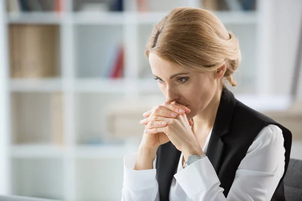 Company director sitting quietly in an office, weighing up her options