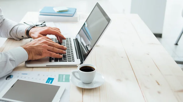 Adviser typing up notes at a desk before a director meeting
